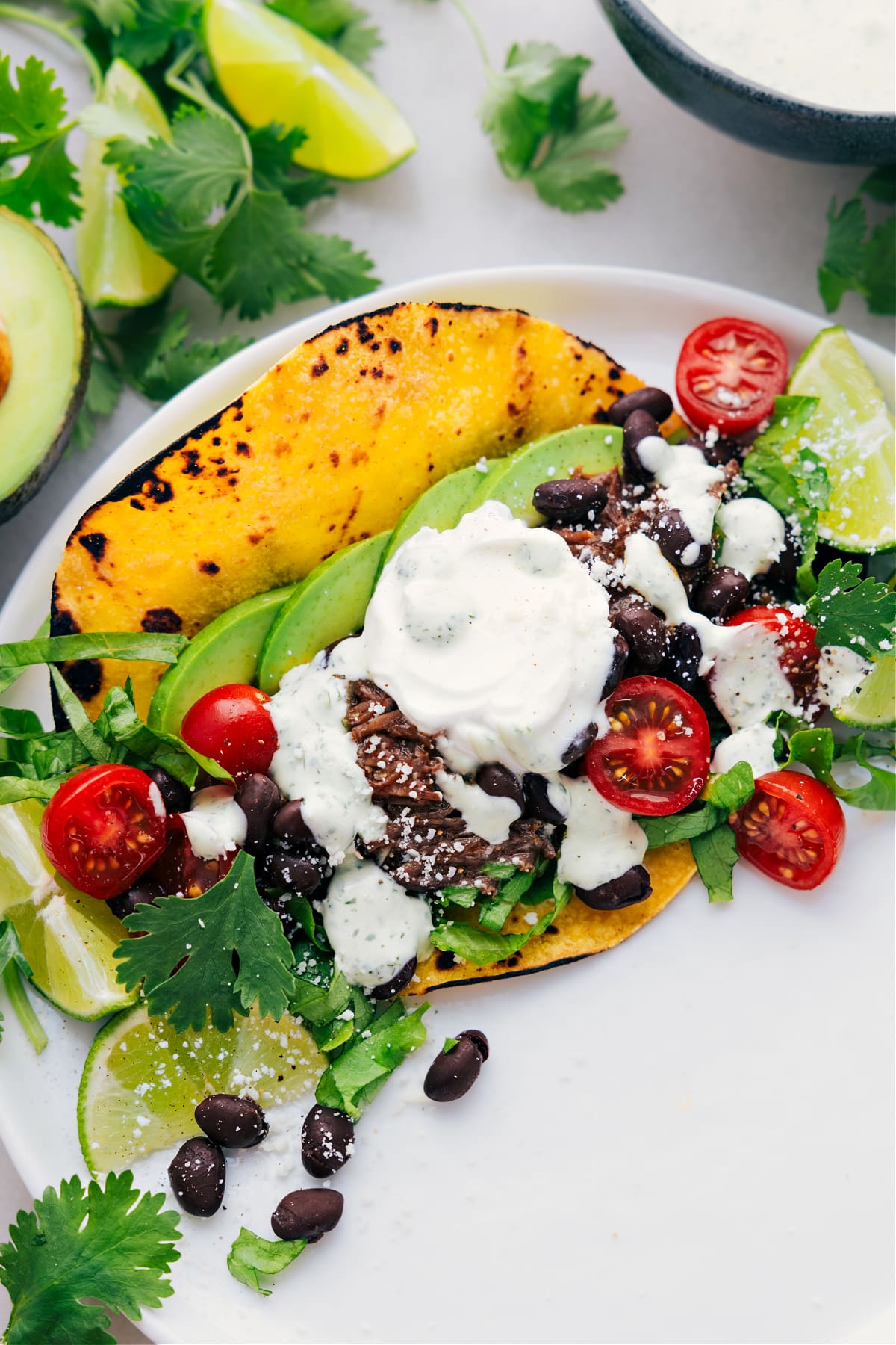 Shredded Beef Tacos on a plate with all the delicious toppings.