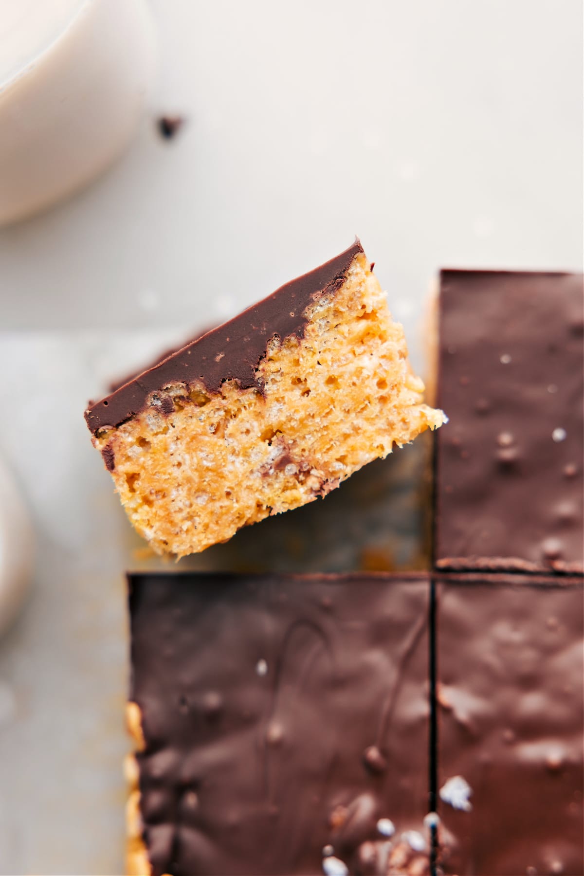 The peanut butter Rice Krispie treats are cut into squares, with one on its side, showcasing its delicious, marshmallowy texture.