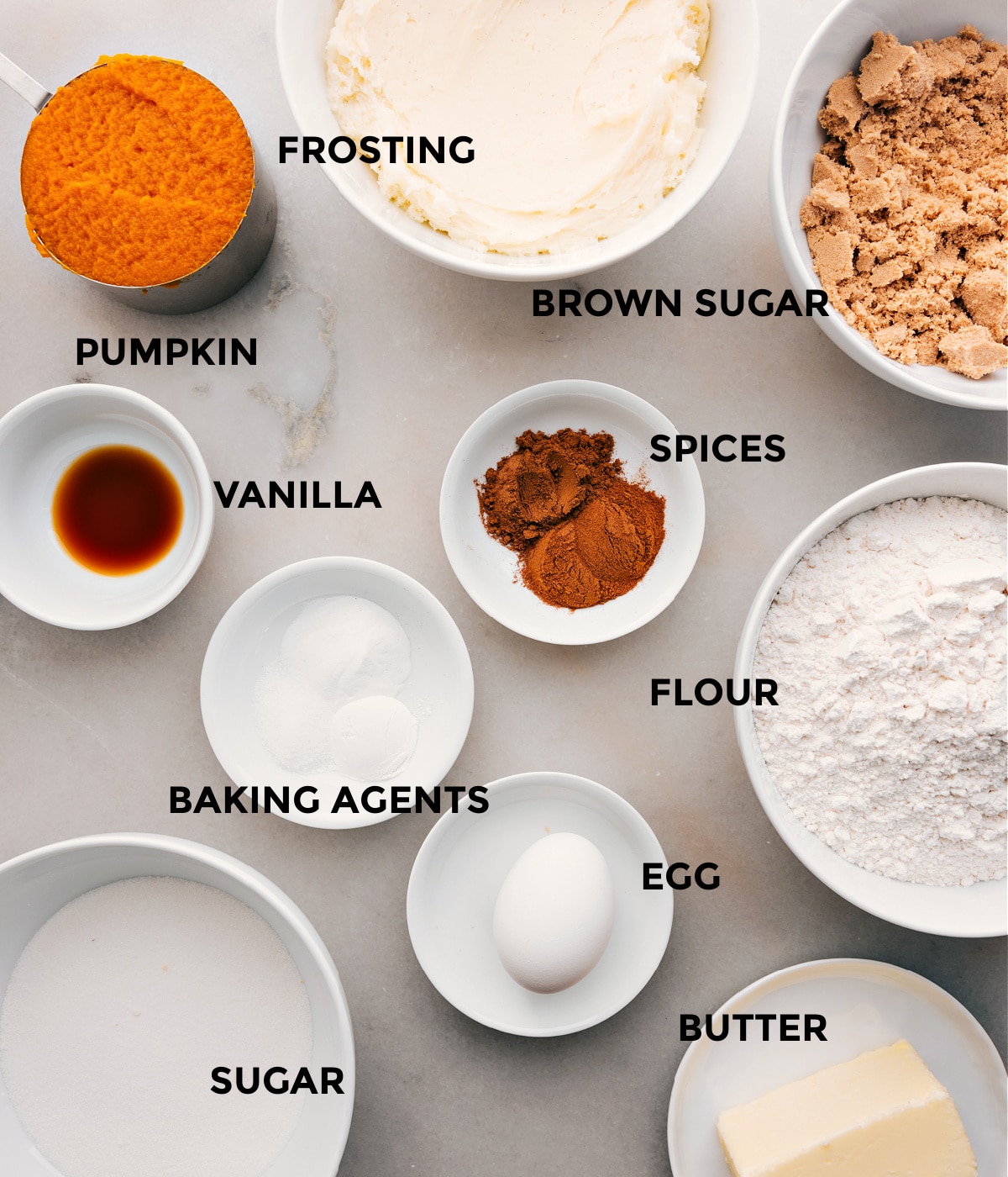 This recipe's ingredients—sugar, spices, flour, baking agents, egg, butter, vanilla, and pumpkin—are prepped for easy assembly.