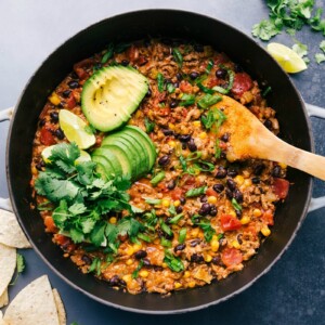 A finished turkey taco skillet, garnished with avocado slices, cilantro, and lime, creating a warm and hearty meal.