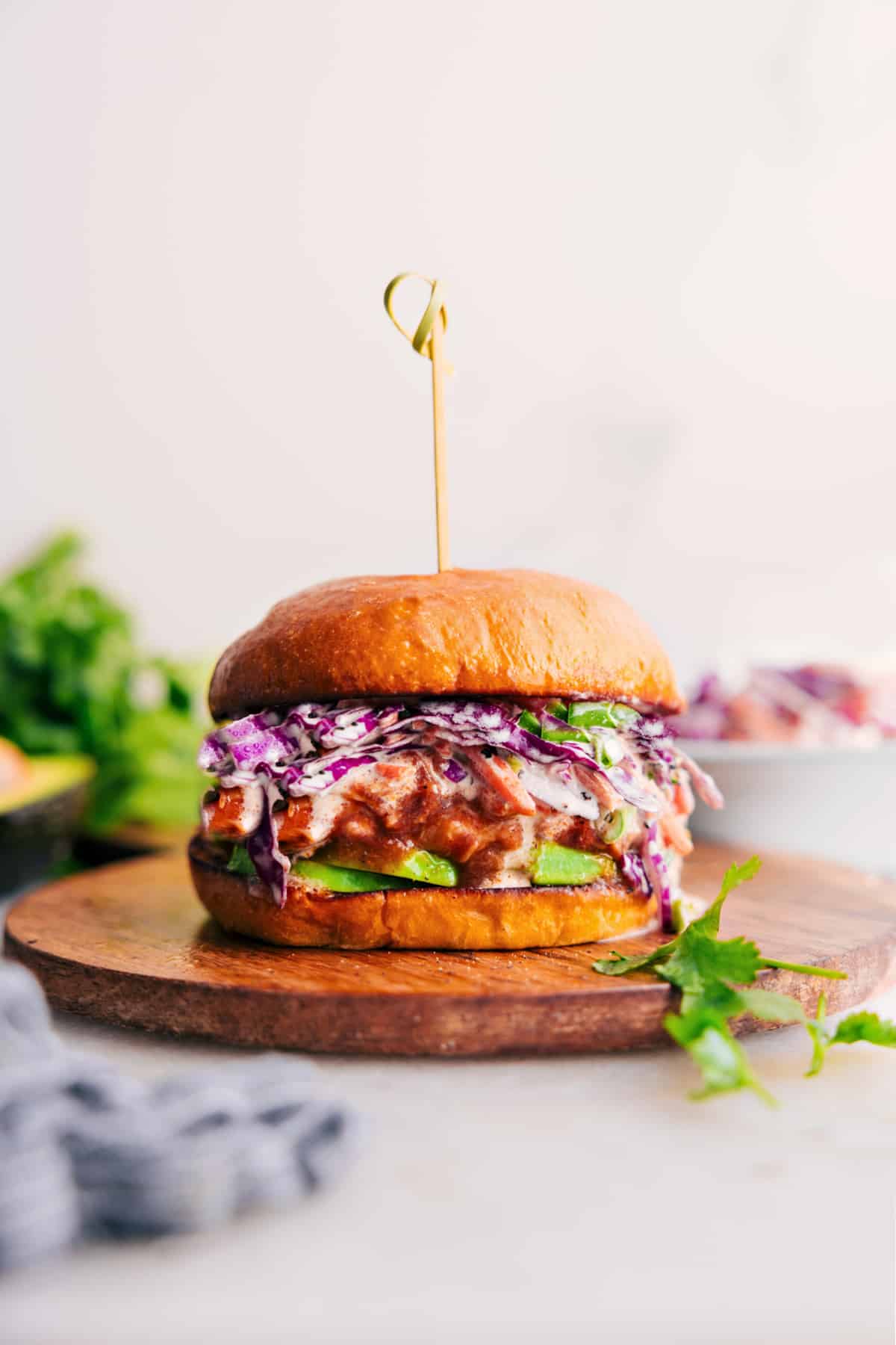 Crockpot BBQ Chicken on a bun, topped with slaw and avocado.