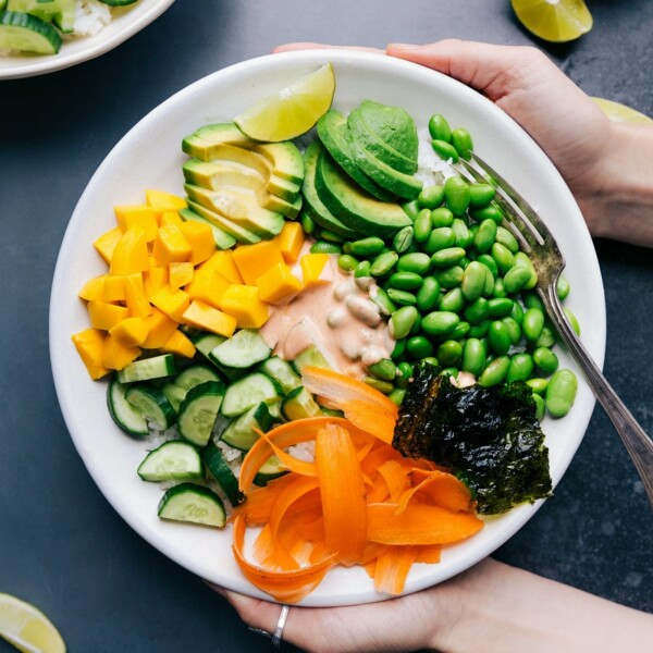 Vegetarian sushi bowl with all the ingredients arranged together and the sauce in the middle.