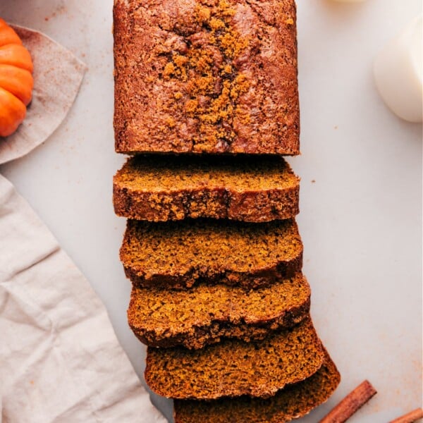 A loaf of the delicious pumpkin bread, with half sliced into individual pieces, ready to enjoy.