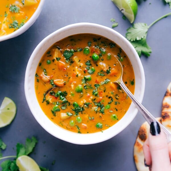 Vibrant and healthy chicken curry soup in a bowl, topped with fresh herbs and ready to be enjoyed.