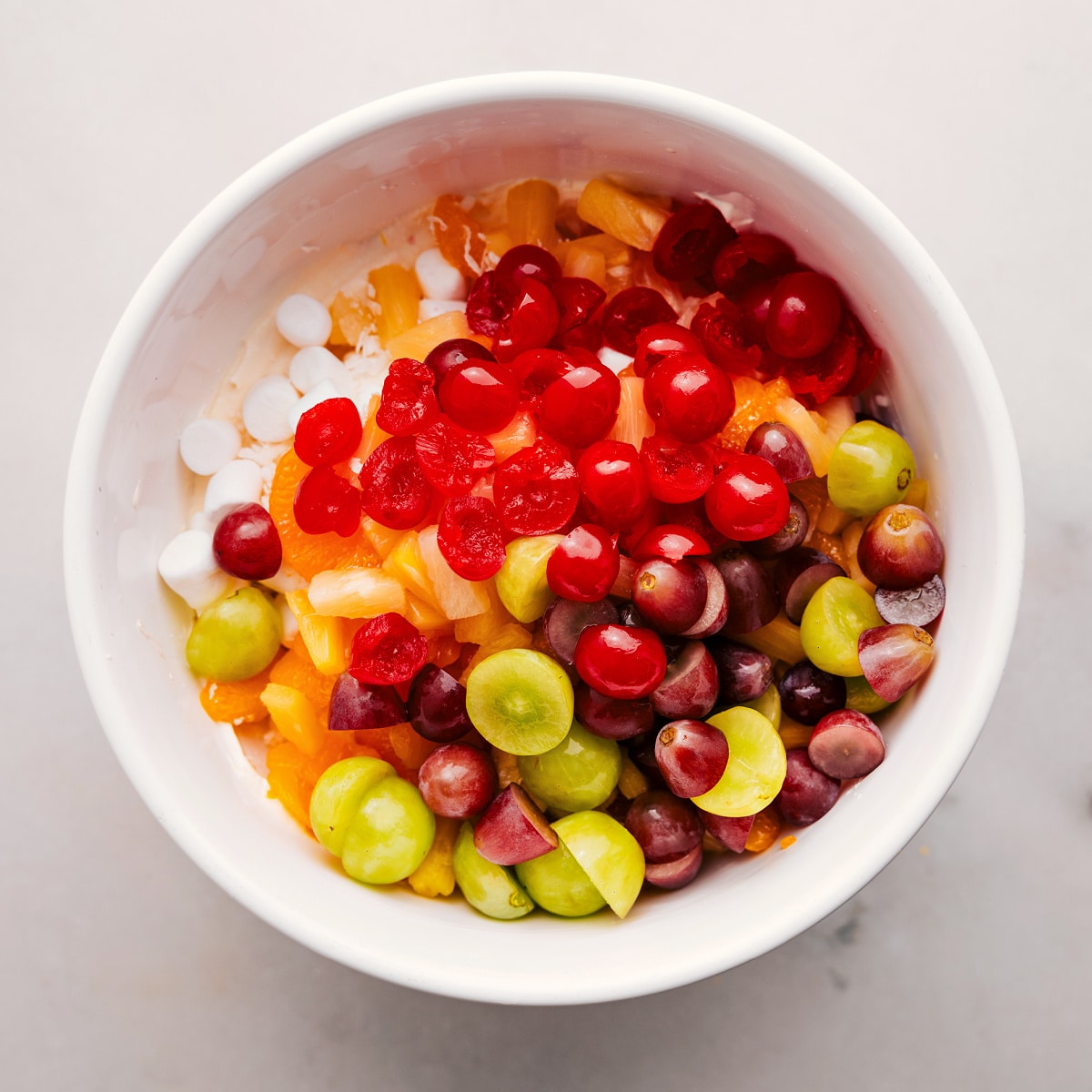 All the fruit and marshmallow ingredients added to a bowl.