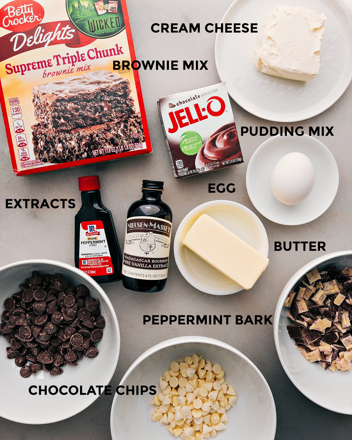 The ingredients for this recipe—brownie mix, pudding mix, cream cheese, egg, butter, extracts, and chocolate chips—are prepped and ready for easy assembly.