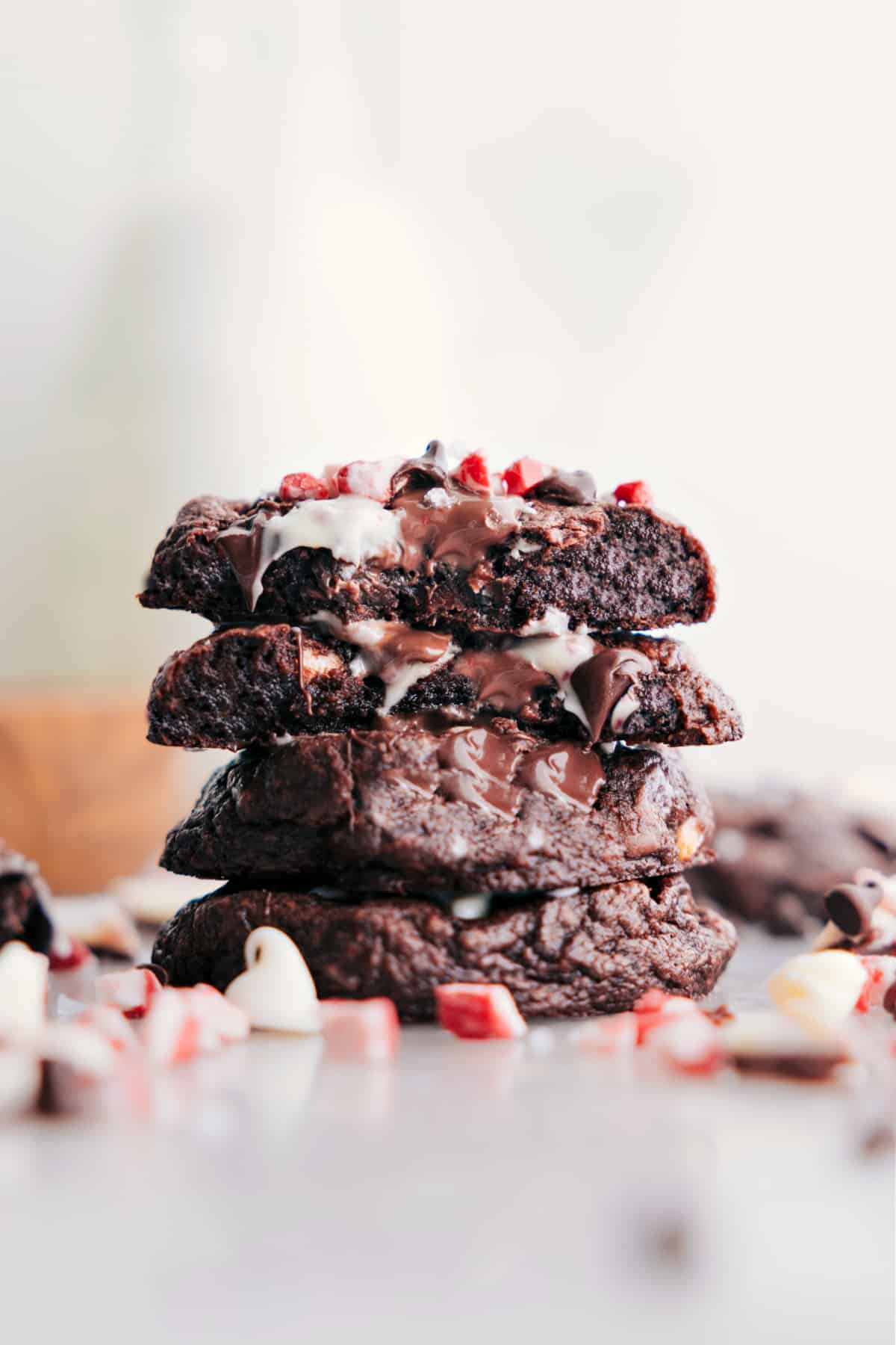 A stack of Chocolate Peppermint Cookies with one split in half, revealing the gooey insides.