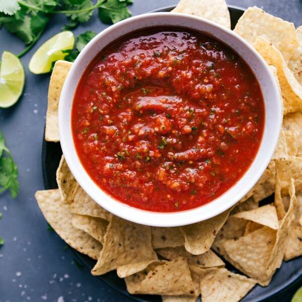 A big bowl of delicious salsa, packed with vibrant flavors, paired with a pile of crispy chips ready for dipping.