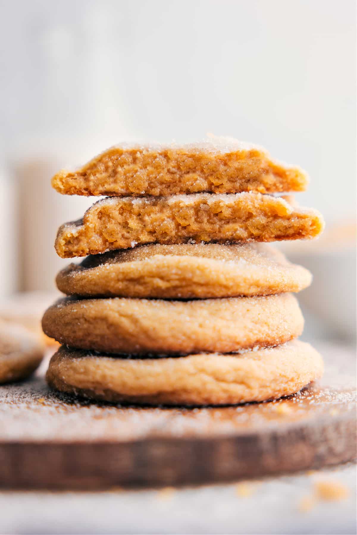 Brown Sugar Cookies stacked on top of each other, with one broken in half to reveal the delicious inside.