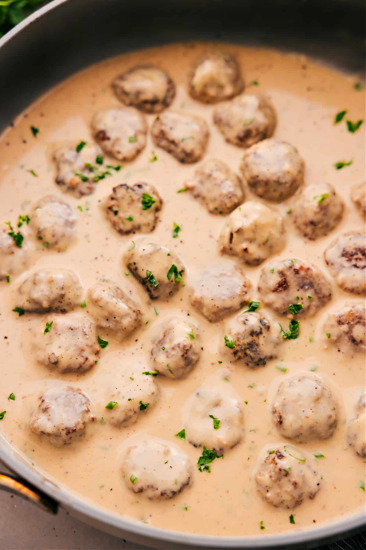 Swedish meatballs in cream sauce, topped with freshly chopped parsley, ready to serve and enjoy.