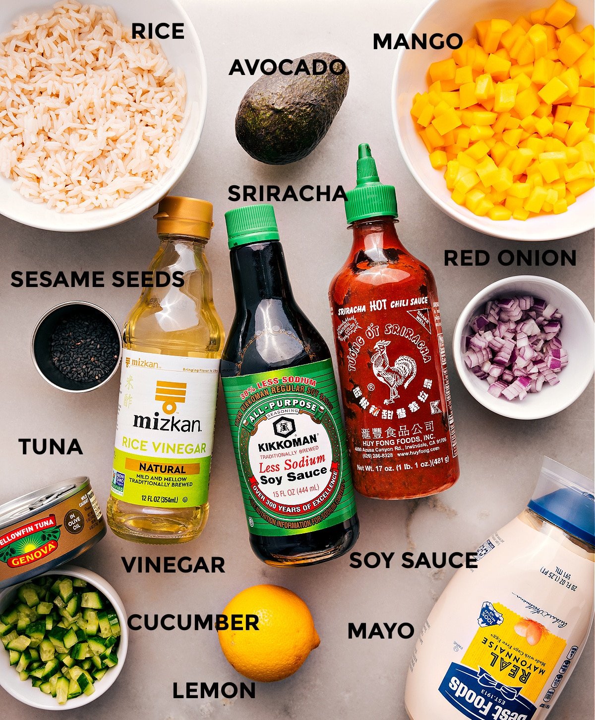 All the ingredients are prepped for easy assembly—mango, onion, soy sauce, sriracha, rice vinegar, rice, avocado, sesame seeds, meat, cucumber, mayo, and lemon.