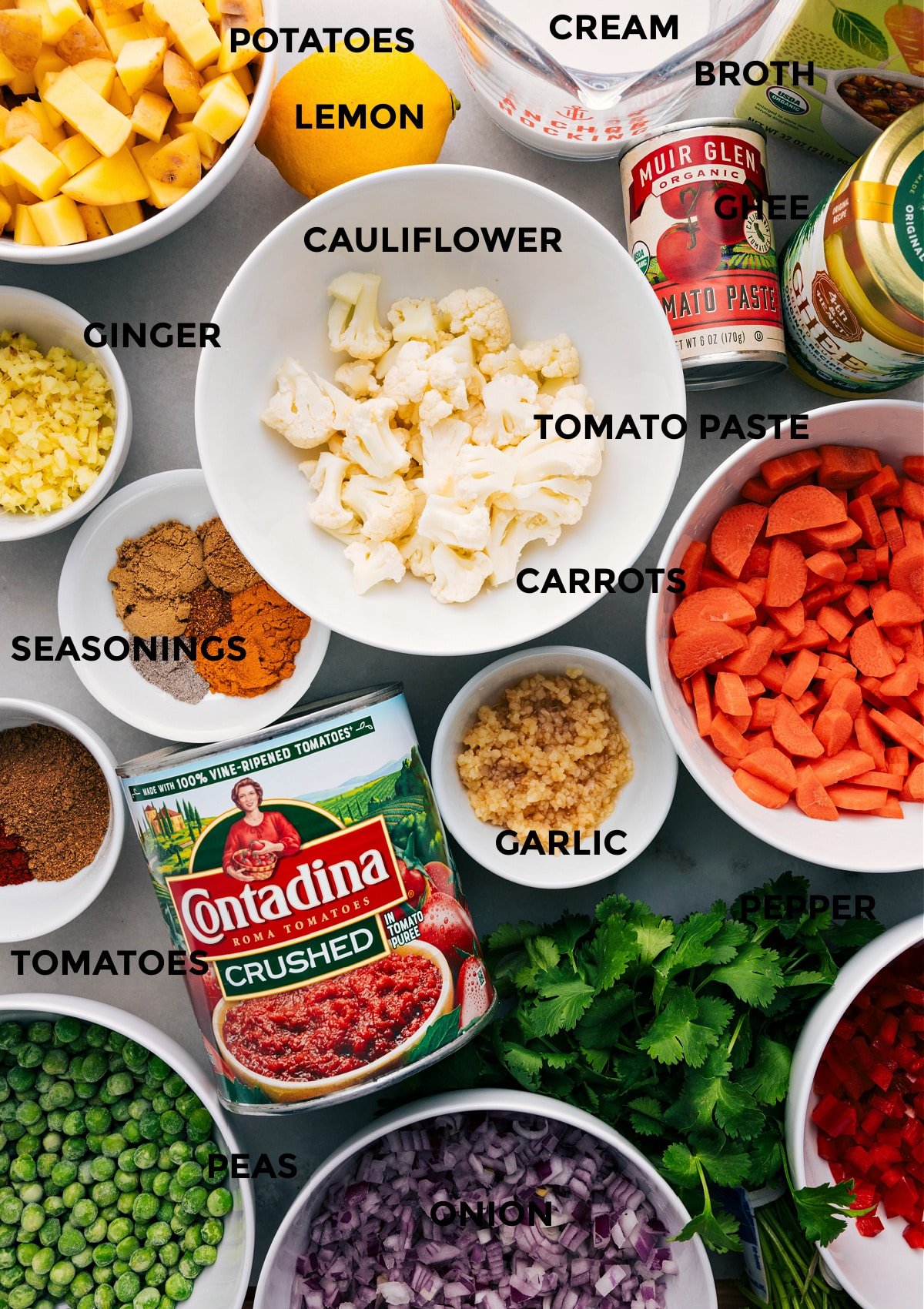 All the ingredients are prepped for easy assembly—veggies, seasonings, tomatoes, ghee, tomato paste, broth, cream, and lemon.