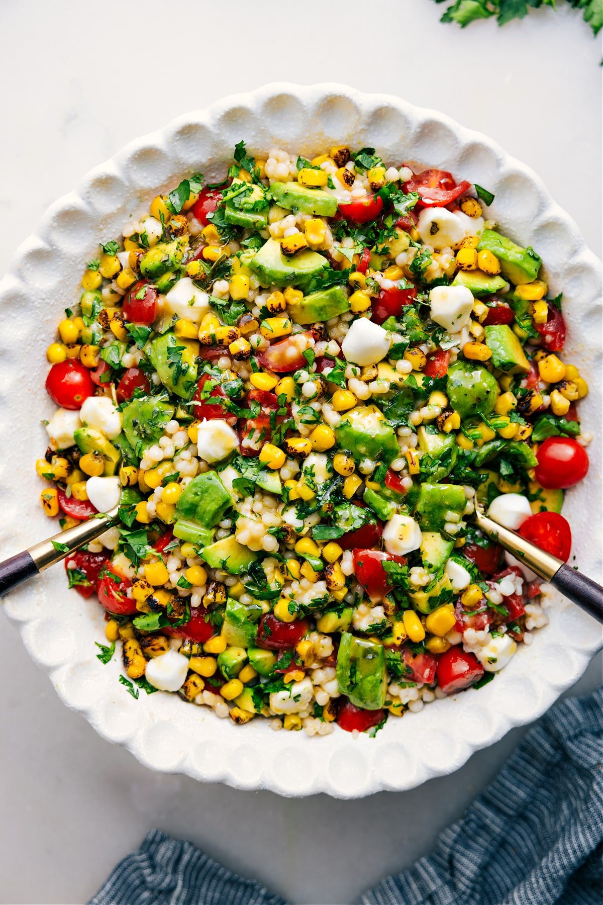 Summer Couscous Salad in a bowl with fresh ingredients and a drizzle of dressing.