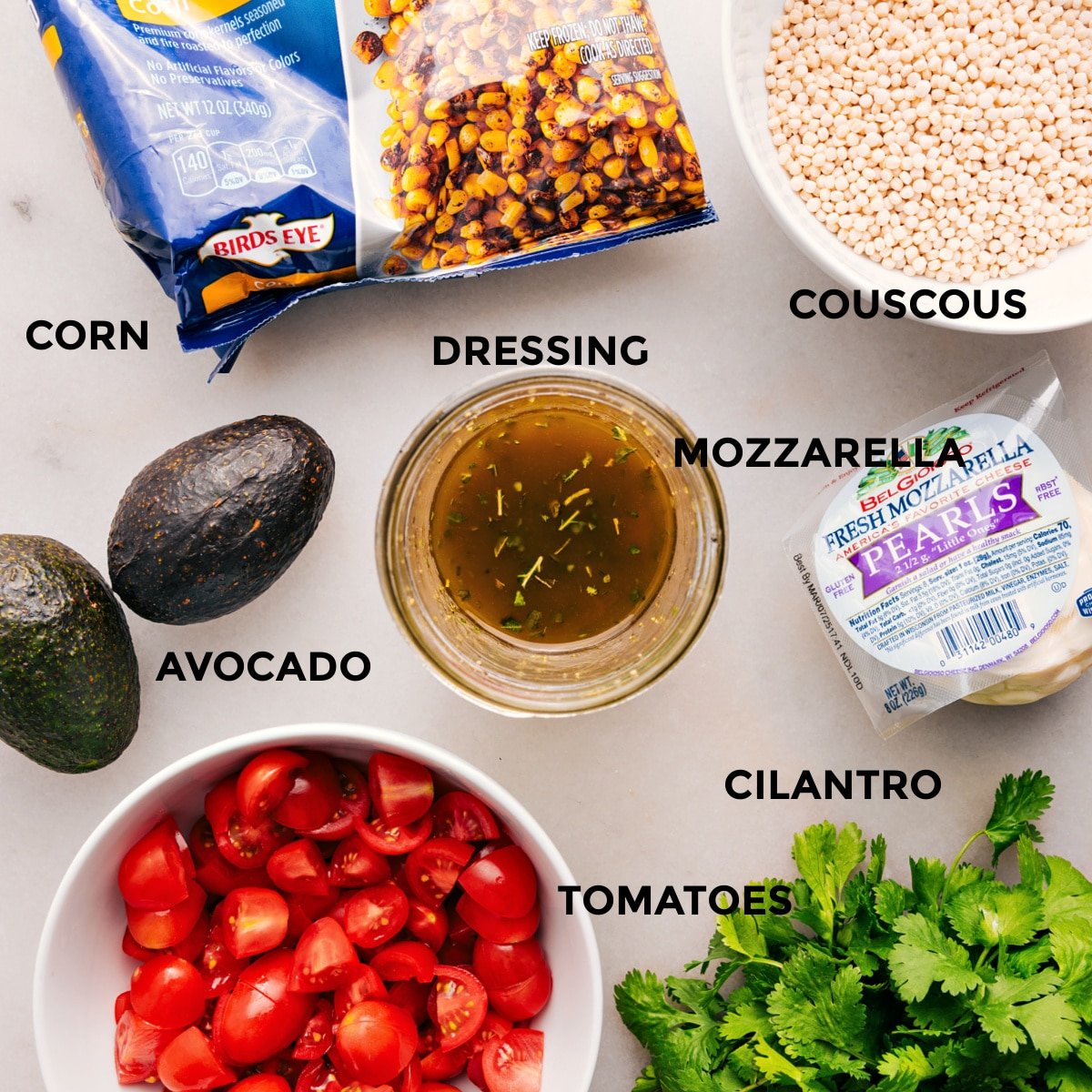 All the ingredients prepped for easy assembly—mozzarella, cilantro, tomatoes, avocado, dressing, grain, and corn.