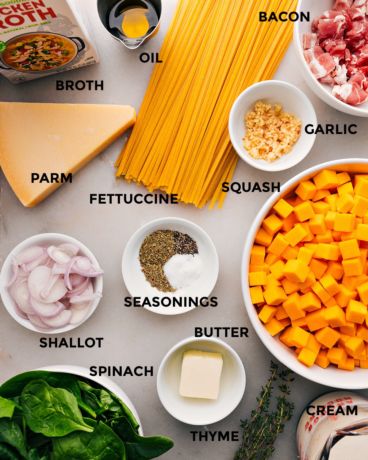 All the ingredients for this recipe are prepped and ready for easy assembly, including fettuccine, garlic, bacon, oil, broth, parmesan, shallots, butter, and veggies.