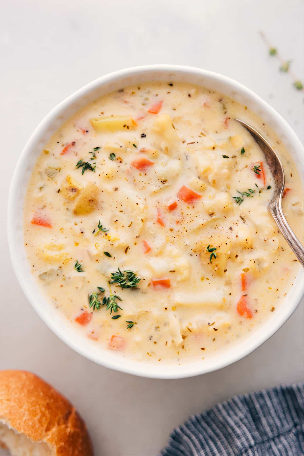 Cauliflower Soup fills a bowl, topped with fresh thyme.