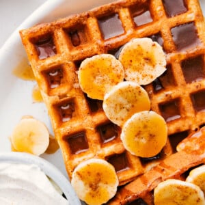 Banana Waffles with syrup and fresh bananas and whipped cream.