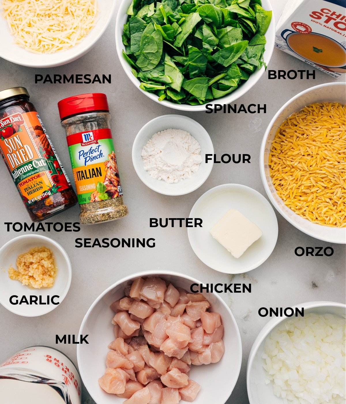 All the ingredients in this recipe are prepped for easy assembly, including spinach, broth, veggies, pasta, meat, seasonings, cheese, and milk.