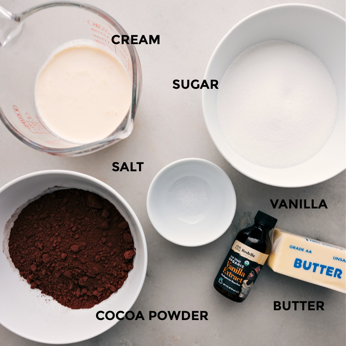 This recipe's ingredients are prepped for easy assembly, including sugar, salt, heavy cream, cocoa powder, vanilla, and butter.