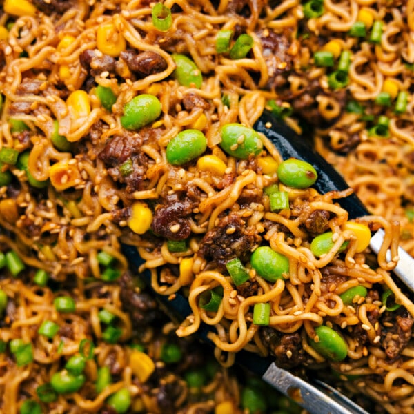 Pork Ramen Stir Fry being picked up with tongs ready to be served and enjoyed.