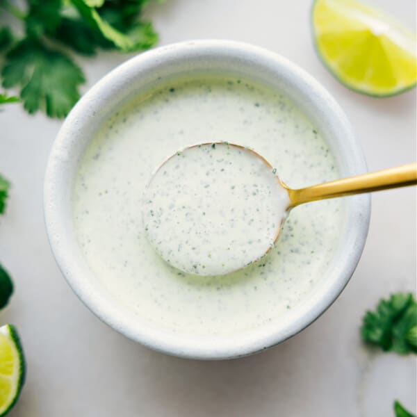 Cilantro Lime Sauce in a bowl with a spoonful coming up.