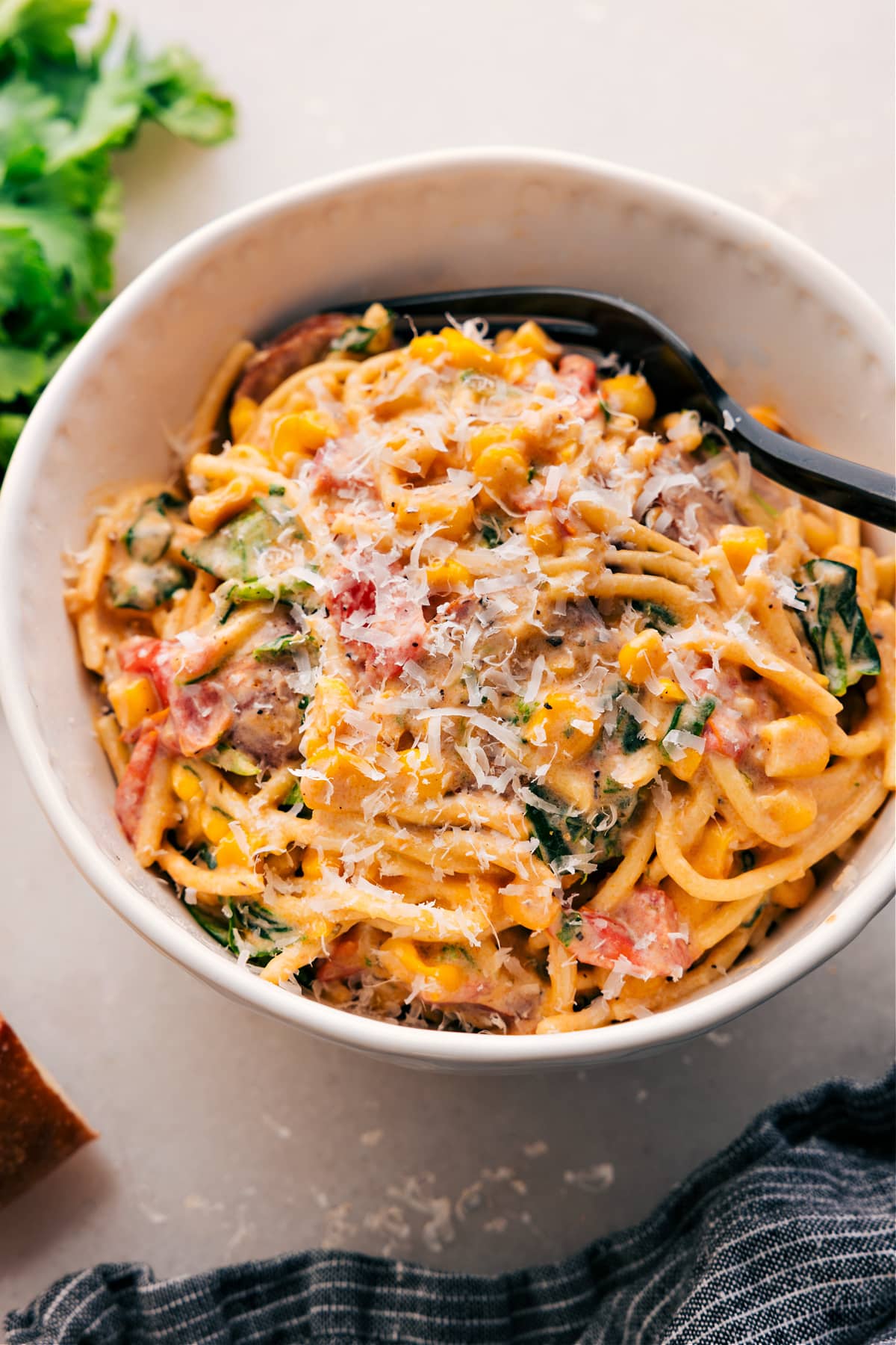 Corn and Sausage Pasta topped with parmesan in a bowl.