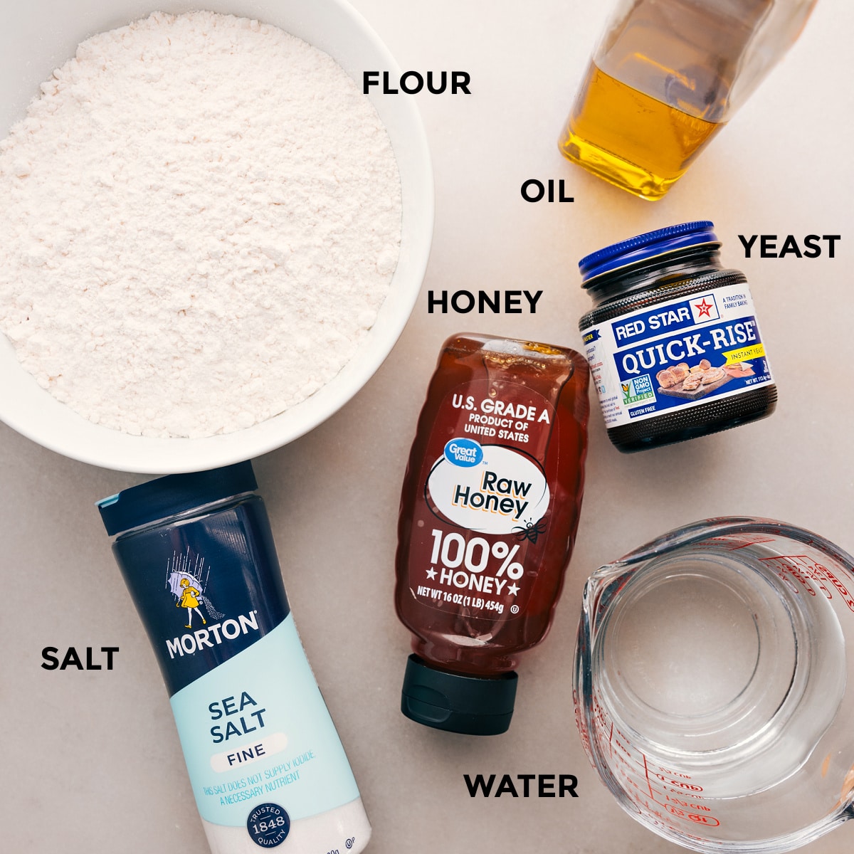 Ingredients for this recipe are prepped for easy assembly: flour, oil, yeast, honey, salt, and water.