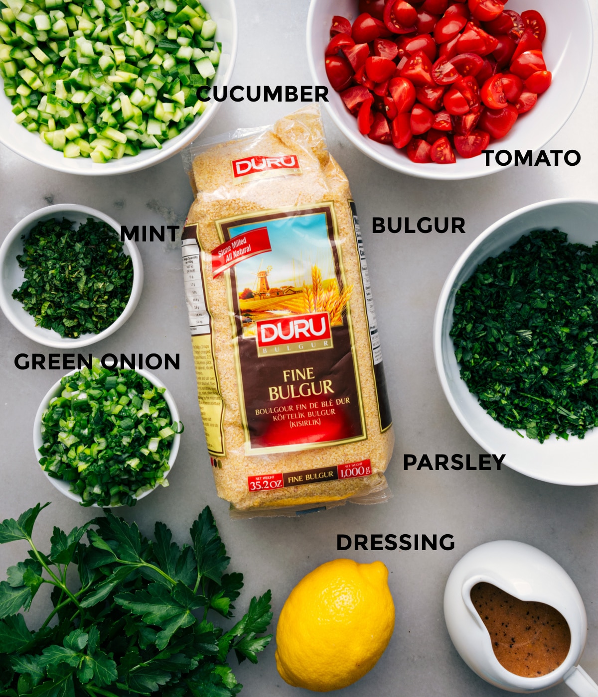 All the ingredients prepped for easy assembly—tomato, herbs, cucumber, bulgur, and dressing.