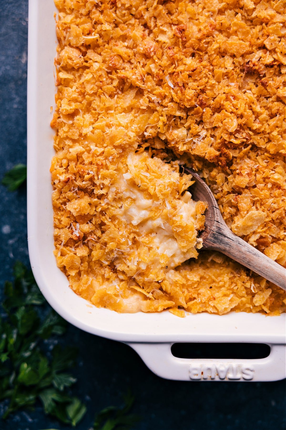 A spoonful of Funeral Potatoes scooped from the casserole dish.