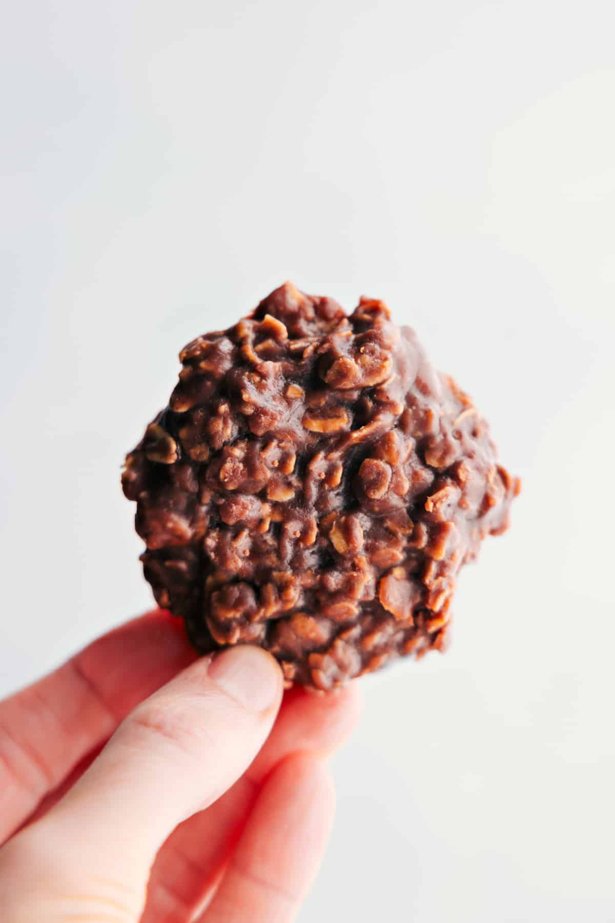 Showing off a no-bake cookie to highlight its deliciousness and texture.