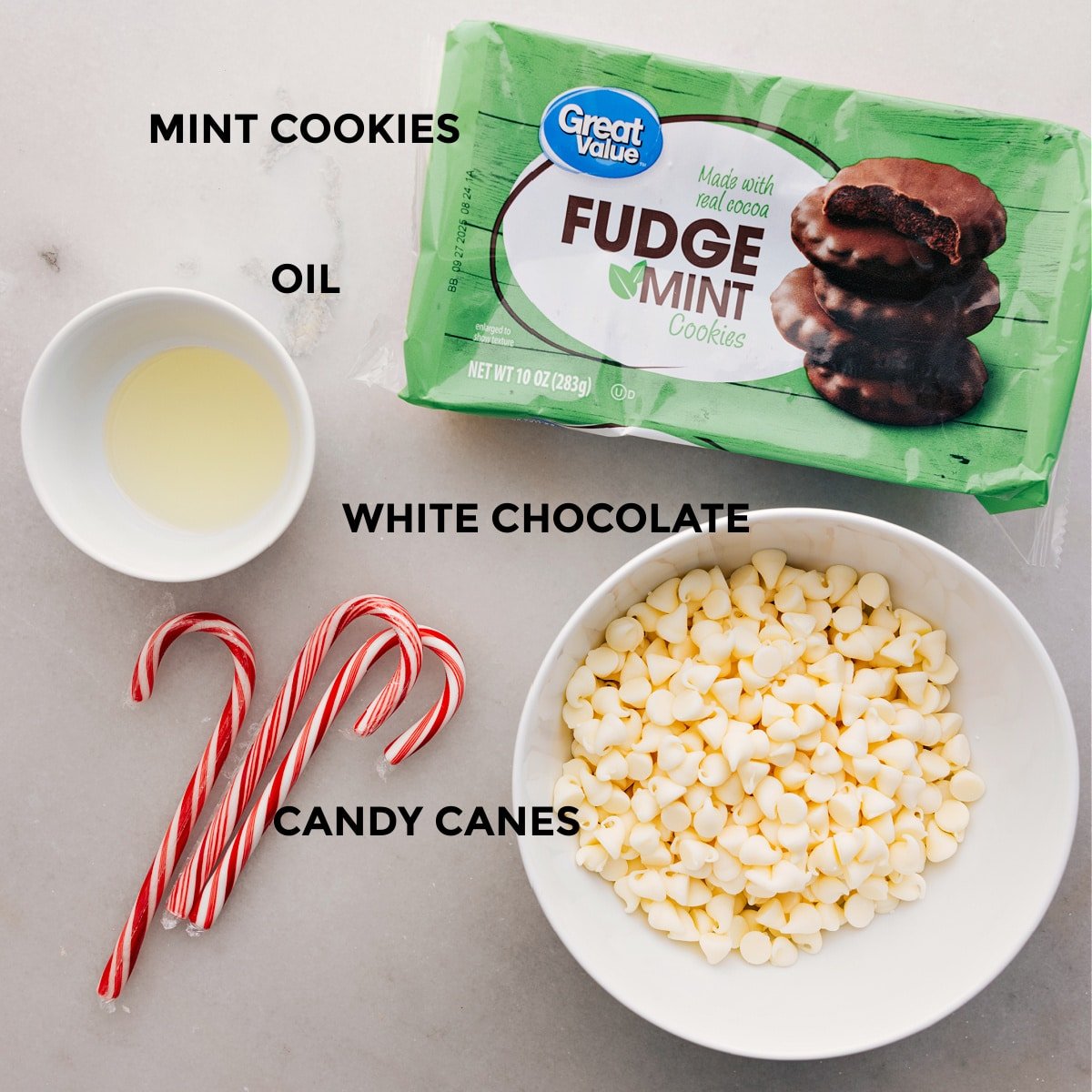 The four ingredients for this recipe are prepped and ready: fudge mint cookies, white chocolate, candy canes, and oil.