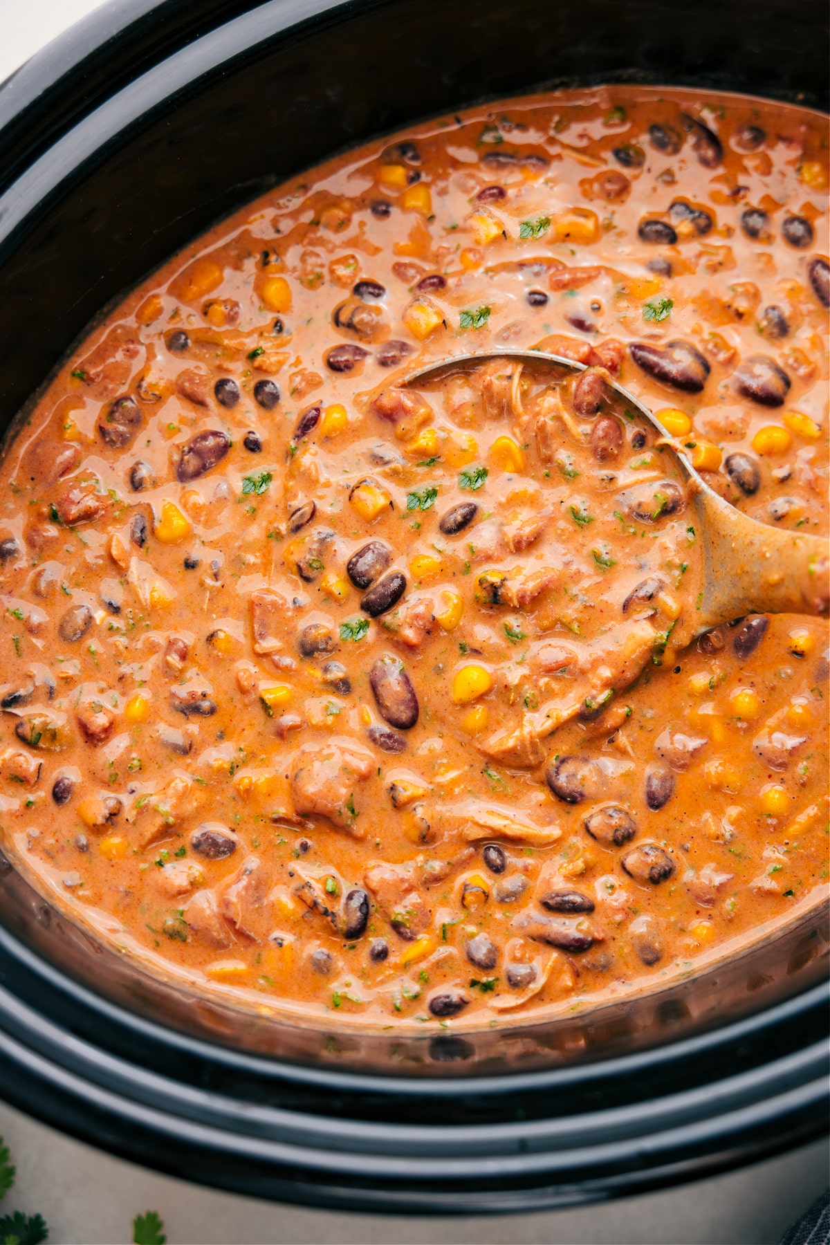 Scooping out Chicken Taco Chili from the crockpot with a ladle.