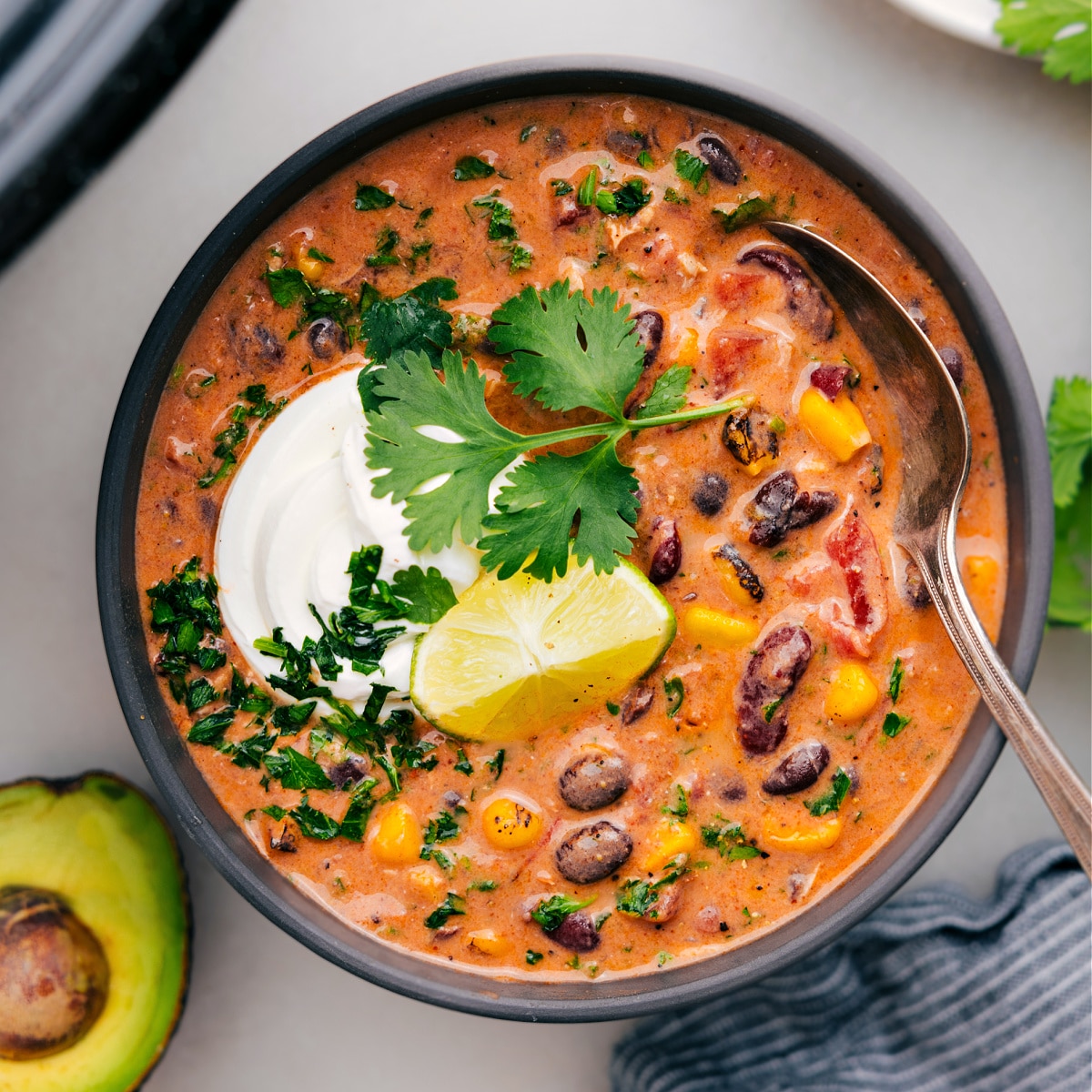 Chicken taco chili in a bowl with all the toppings.