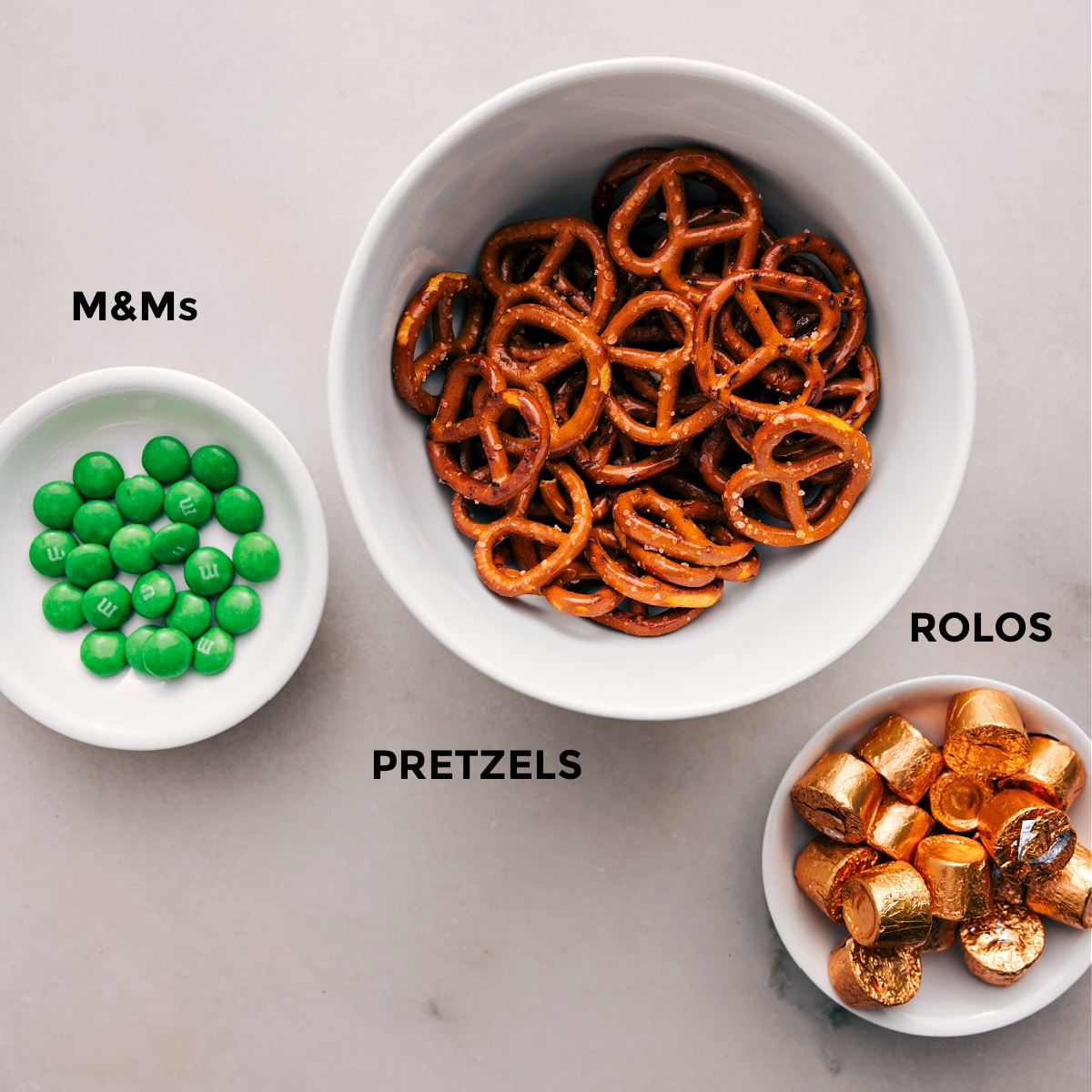 The 3 simple ingredients—M&Ms, pretzels, and Rolos—are prepped for easy assembly.