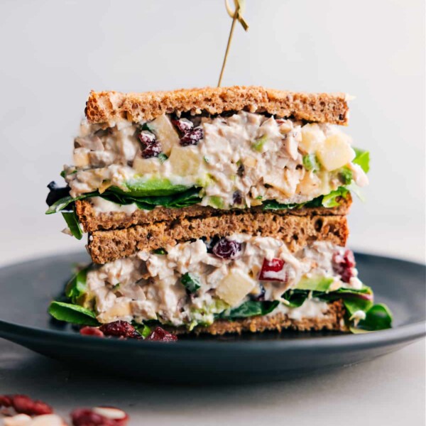 Stacked half-cut chicken salad with apples, showcasing the flavorful filling inside.