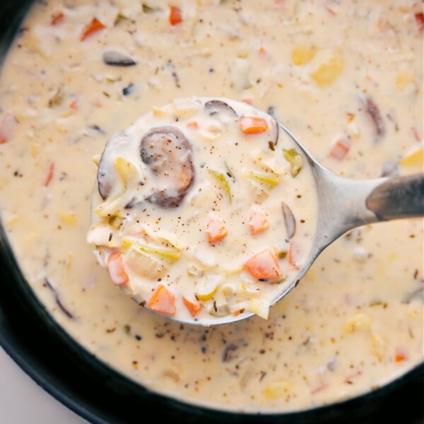 Creamy and rich artichoke soup, with a wooden ladle scooping out a steaming serving ready to be enjoyed.