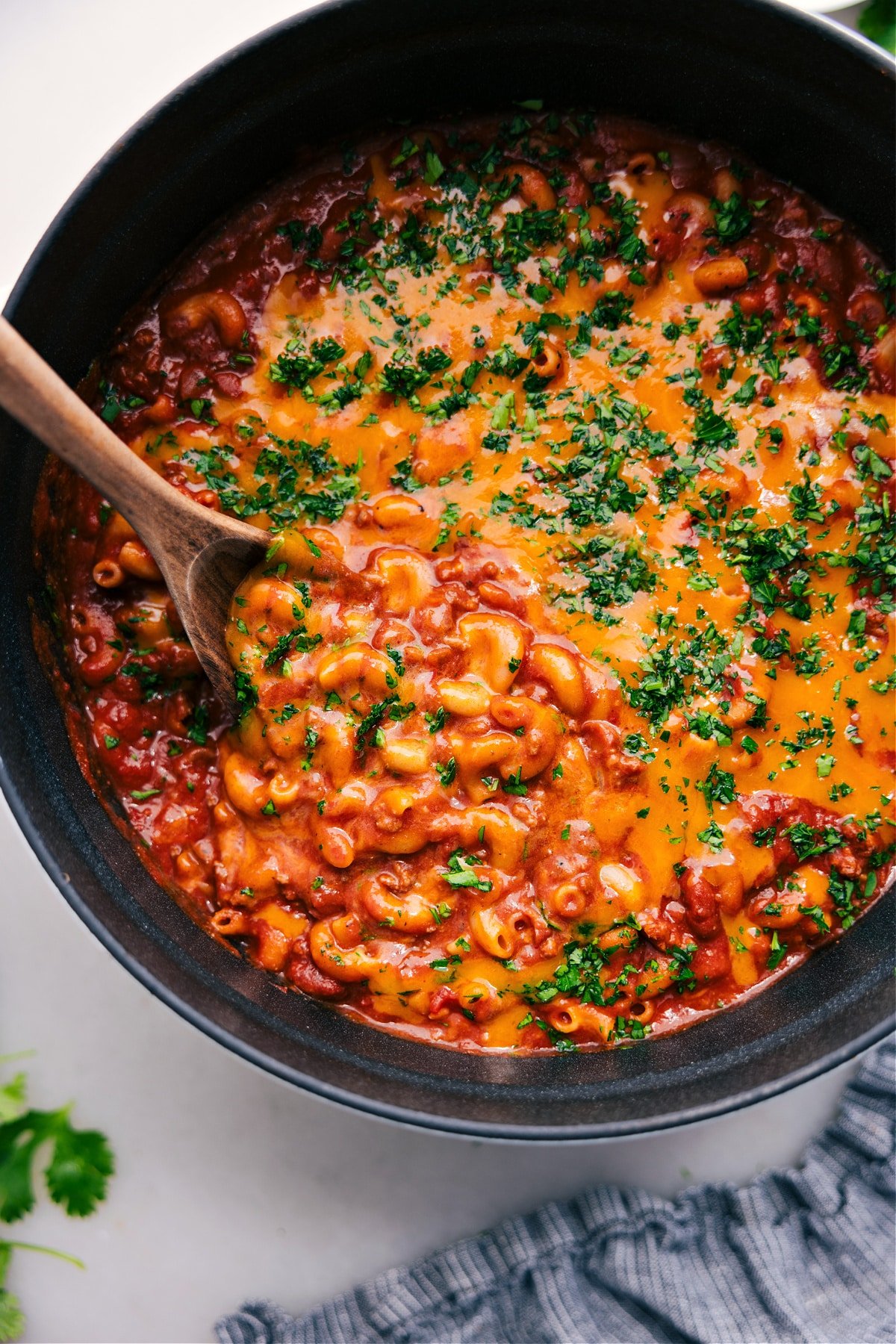 Chili mac in the pot with a spoonful coming out.