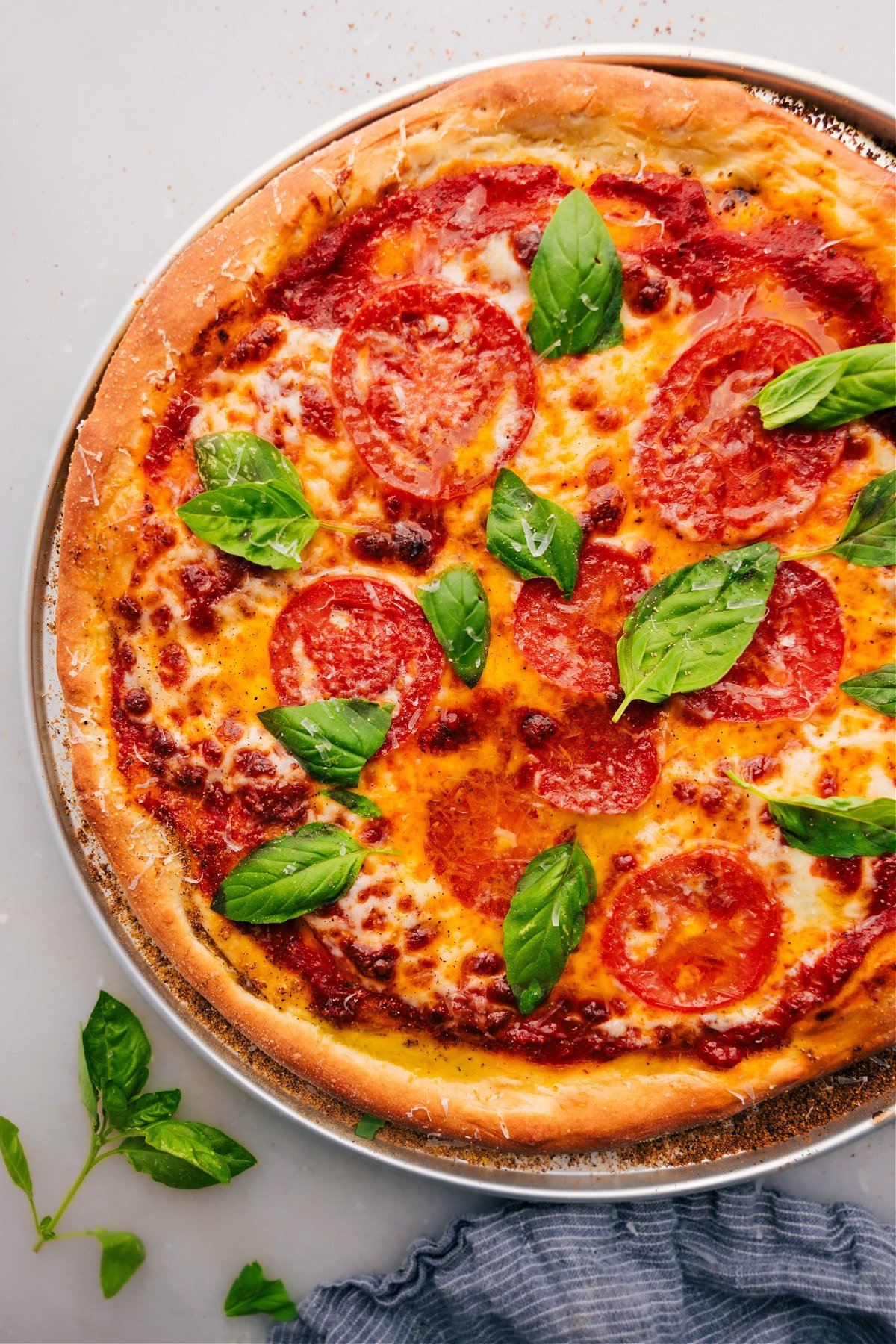 Enjoy this pizza dough recipe baked with cheese, tomatoes, and fresh basil.