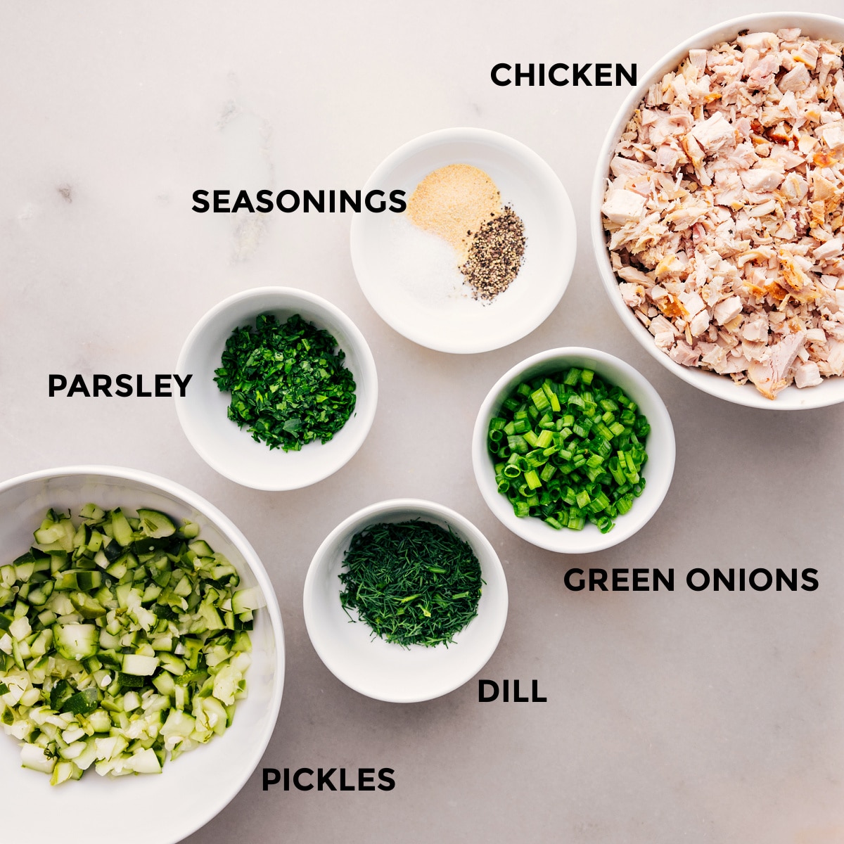 Prep all the dill pickle chicken salad ingredients for easy assembly: chicken, green onions, dill, parsley, pickles, and seasonings.