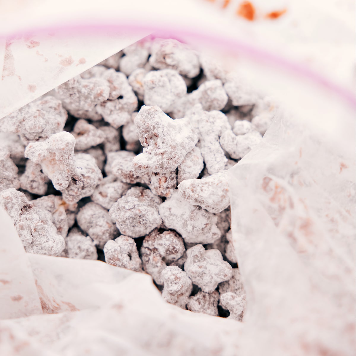 Toss the snack mix in a bag with powdered sugar to coat everything evenly.