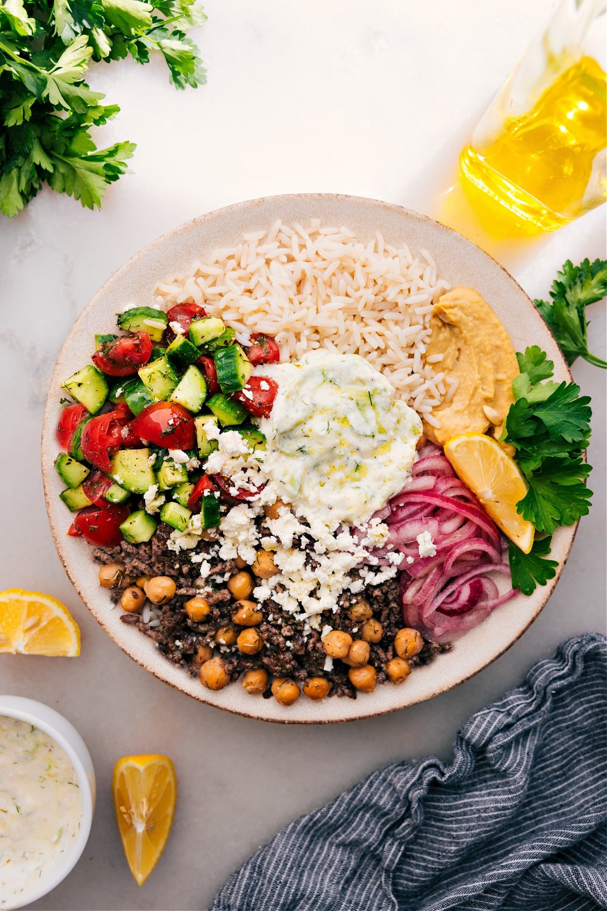 Greek Beef Bowl with rice, tzatziki, Greek salad, pickled red onions, and hummus.