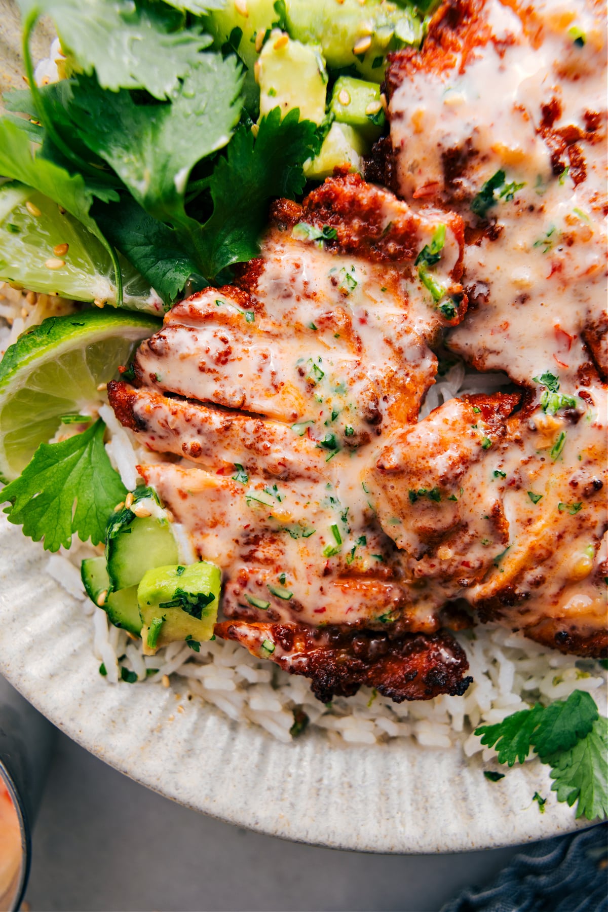 Bang Bang Chicken served on a bed of rice, topped with Bang Bang sauce and a sprinkle of lime zest.