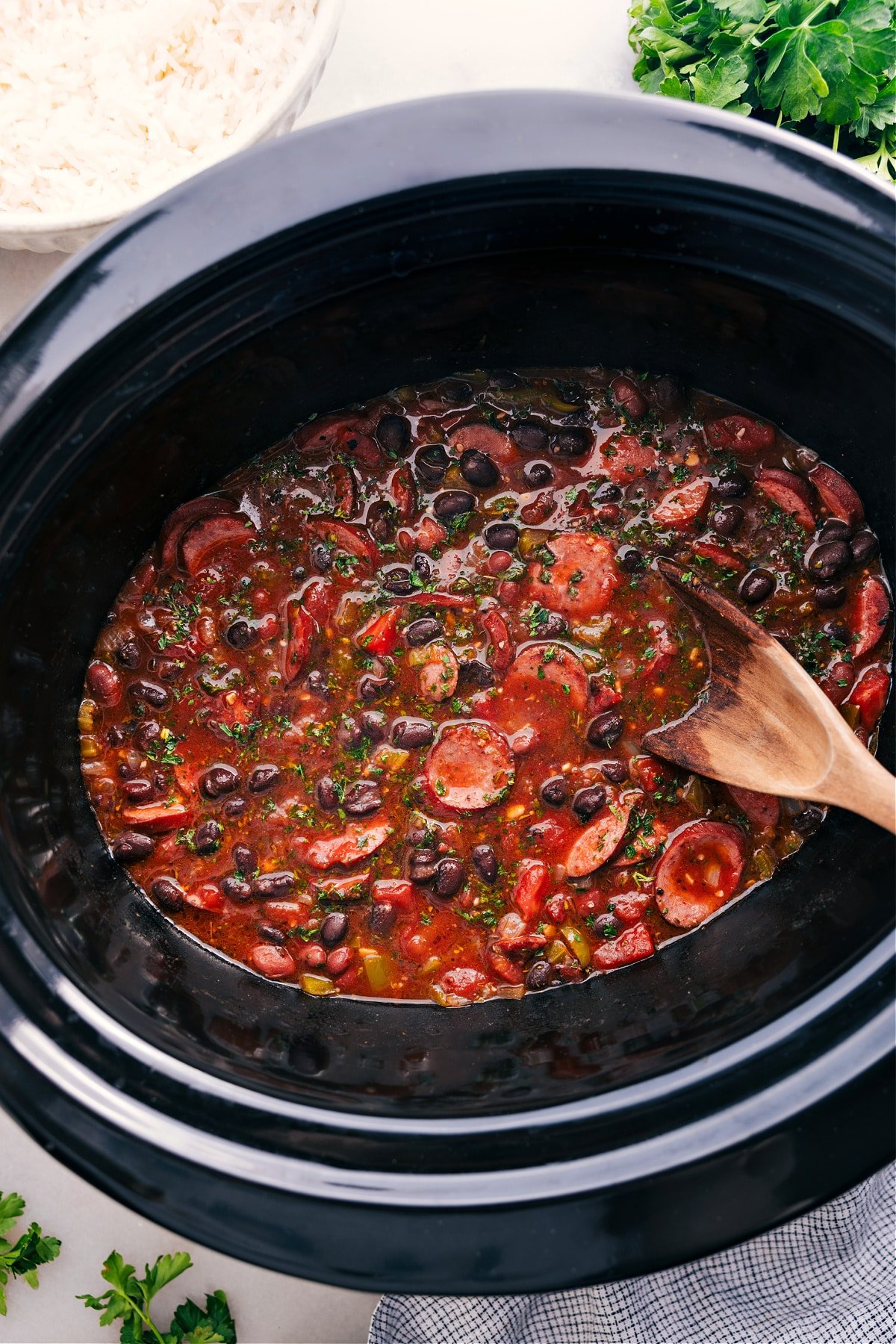 Black beans and sausage cook in the crockpot, ready to serve over rice and enjoy.