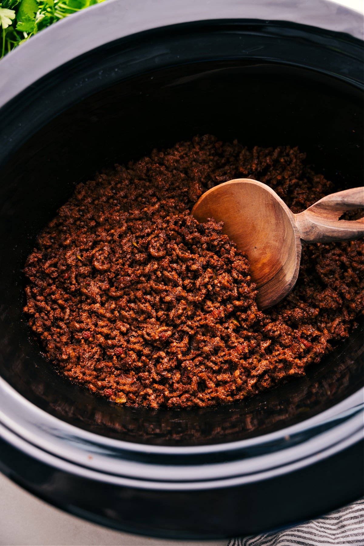 Crockpot Taco Meat in the slow cooker, with a spoon scooping it up.