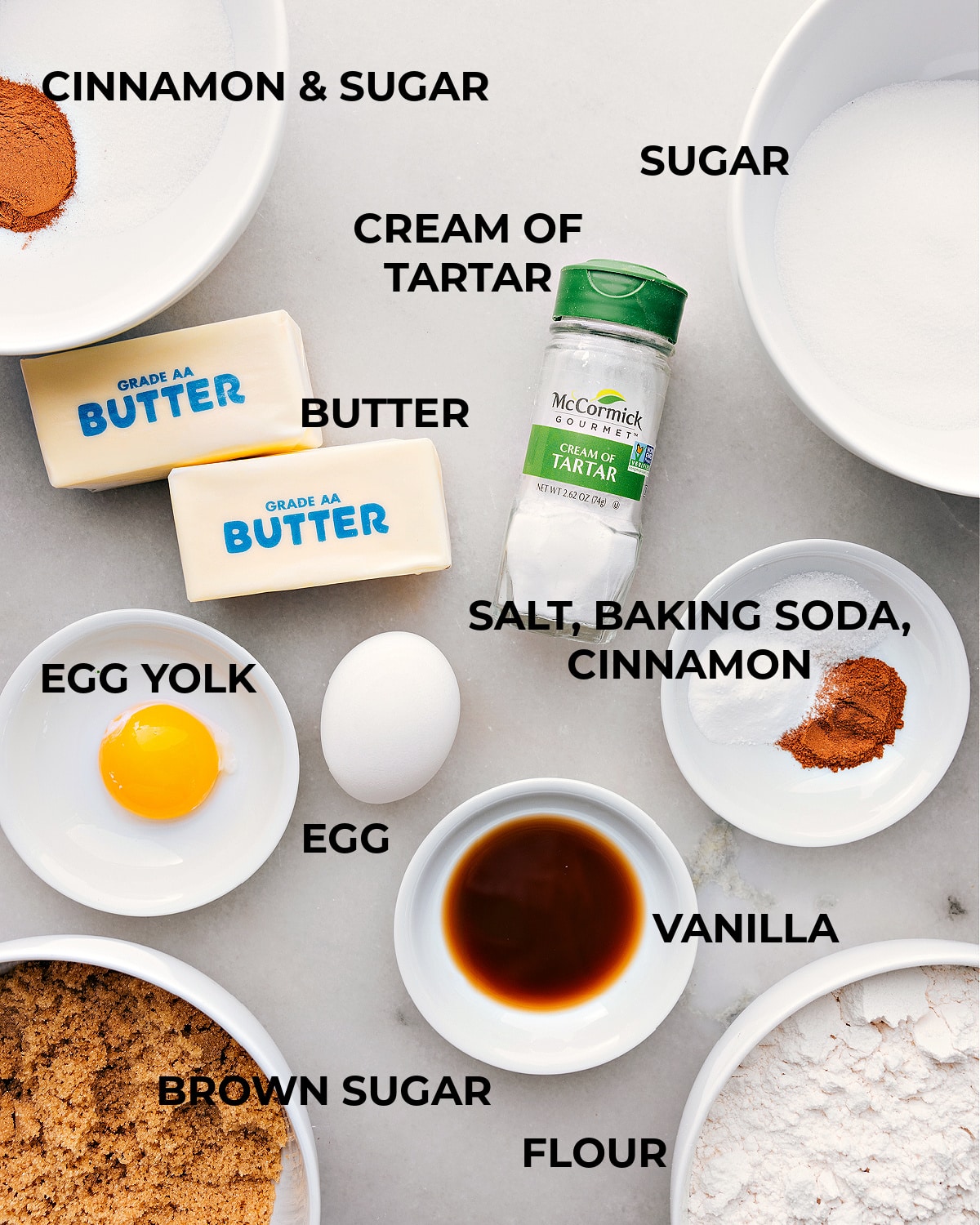 All the ingredients for this recipe are prepped and ready for easy assembly: eggs, vanilla, sugar, butter, flour, baking soda, cinnamon, and cream of tartar.