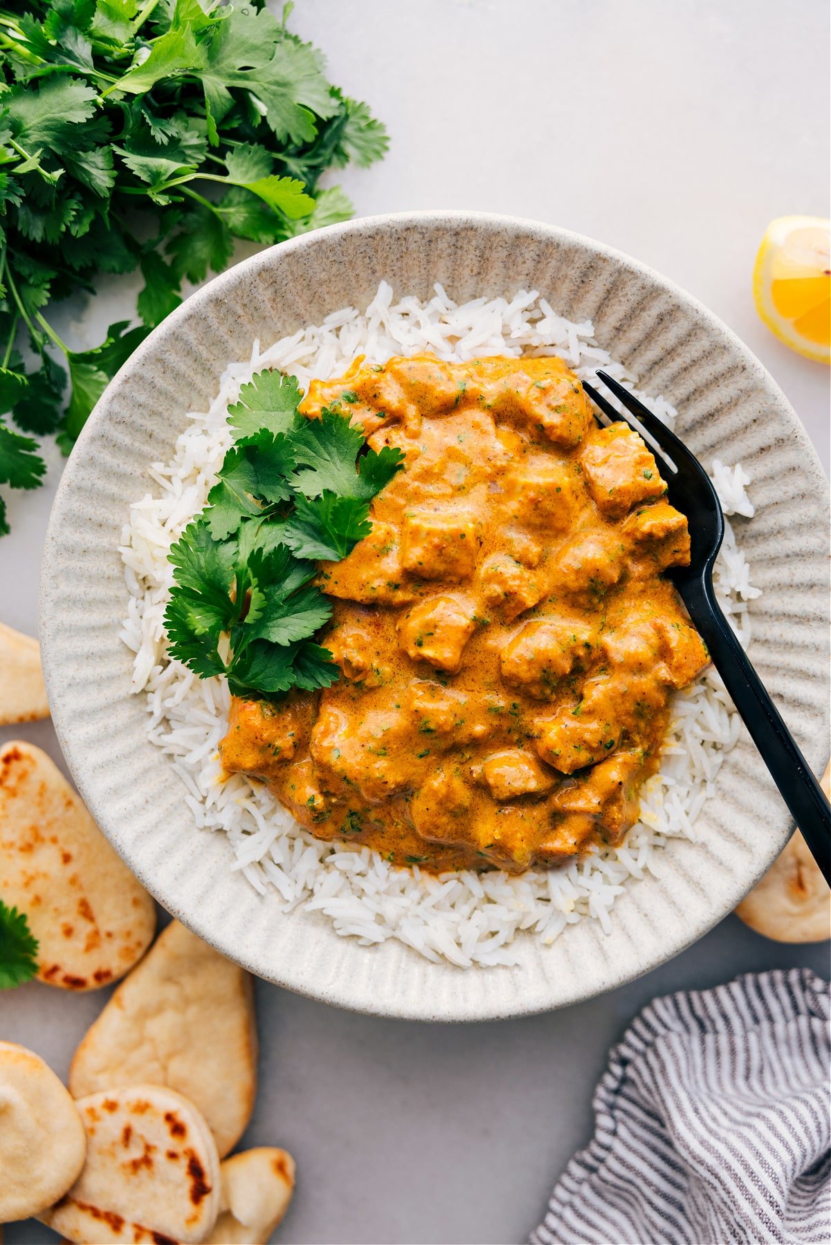 Crockpot Butter Chicken served over a bed of rice, topped with fresh cilantro, and ready to enjoy.