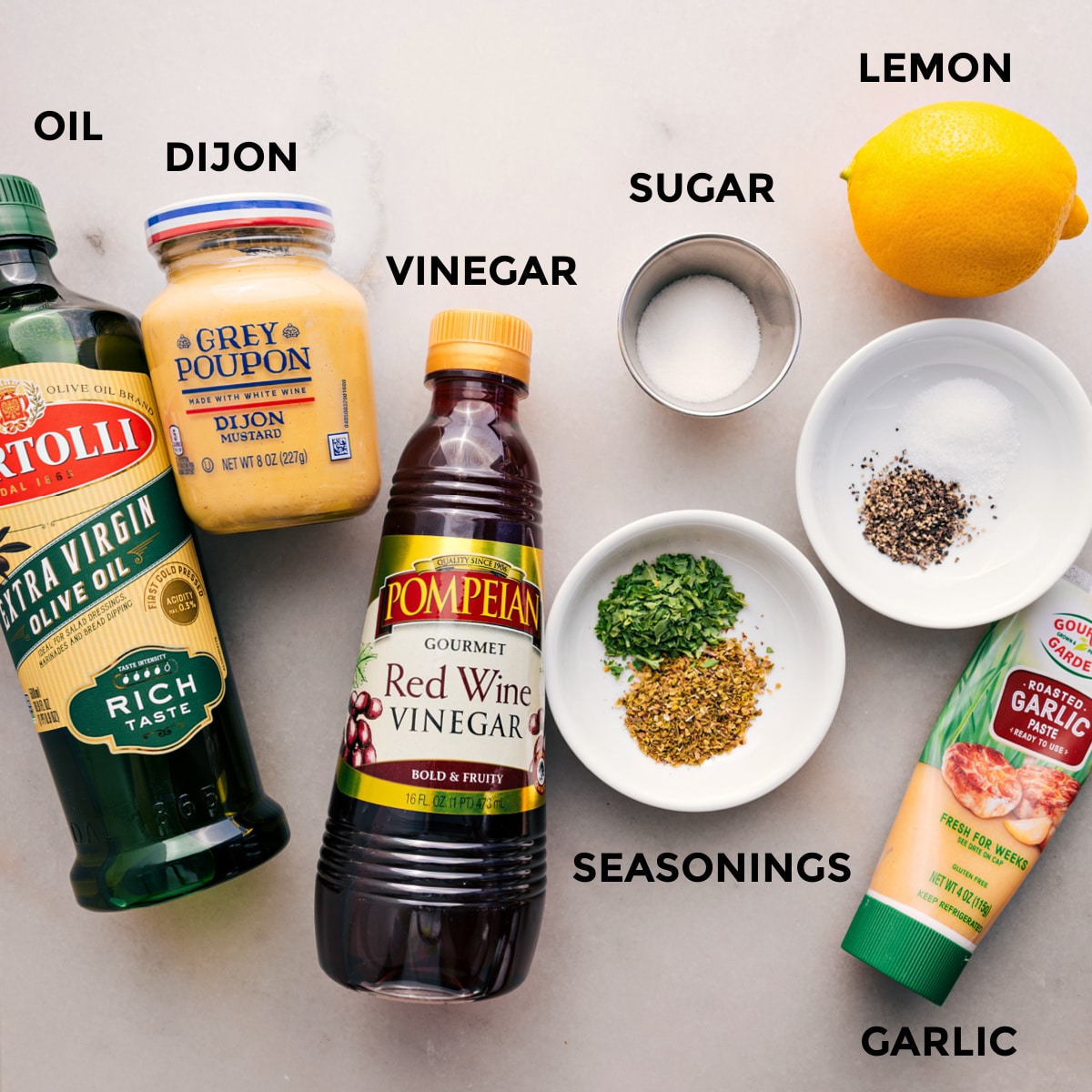 All the dressing ingredients for chopped chicken salad are prepped for easy assembly: seasoning, garlic, oil, mustard, vinegar, sugar, and lemon.