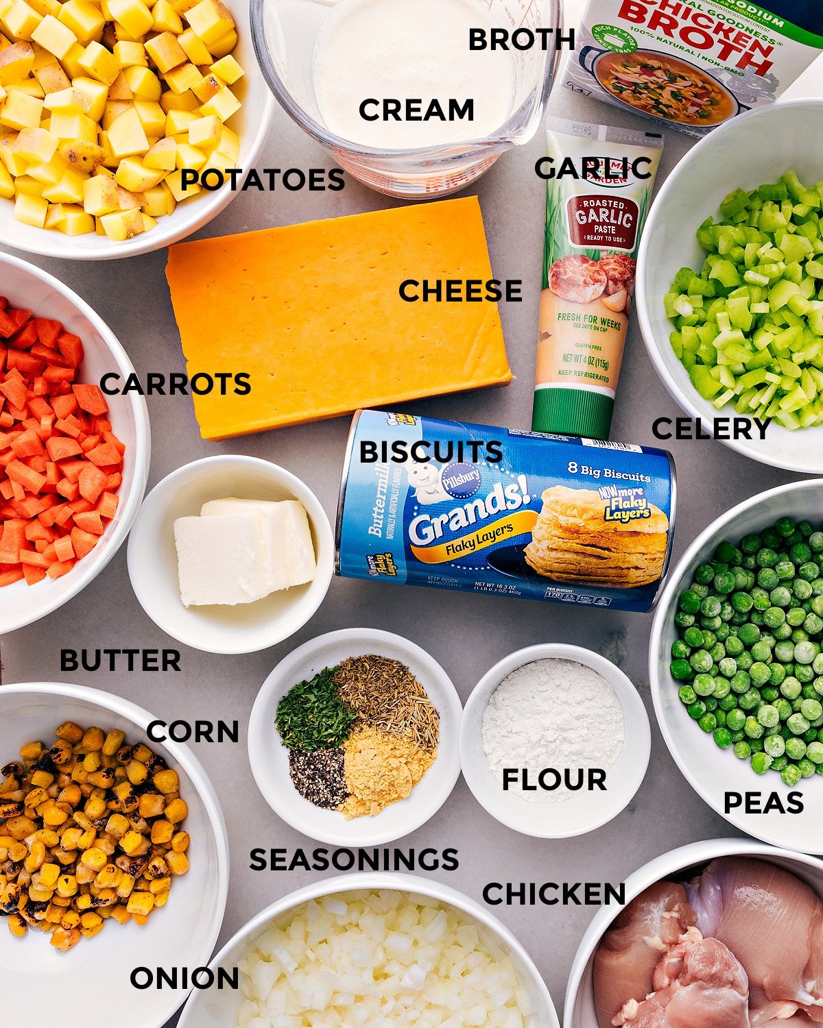 Crockpot Chicken Pot Pie ingredients are prepped for easy assembly, including cheese, celery, veggies, biscuits, flour, meat, broth, and cream.